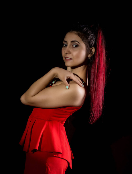 Dość młoda seksowna Azjatka model z rude włosy w niesamowite czerwona sukienka na ciemnym tle - Zdjęcie, obraz
