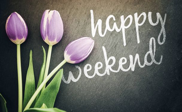 Happy víkend pohlednici pohled shora pastelově fialové tulipány na pozadí tmavě šedé břidlicové tabule - Fotografie, Obrázek