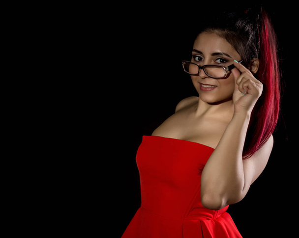 Pretty young sexy asian model with red hair and glasses in amazing red dress. Free space for text - Foto, imagen