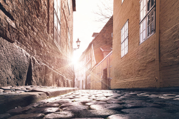 low angle view of sunset in old town alley cobblestone street surface - Photo, Image