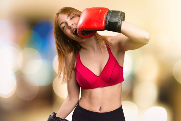 Young sport woman with boxing gloves on unfocused background - Фото, зображення