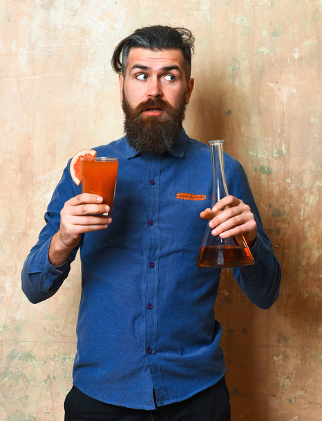 Brutal hipster holding alcoholic shot and glass tube or flask - 写真・画像