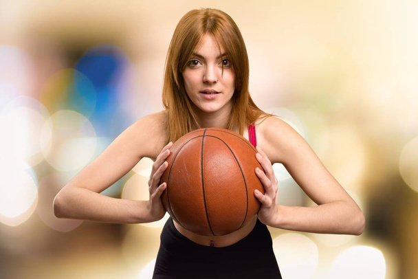 Jeune femme sportive avec balle de basket sur fond flou
 - Photo, image