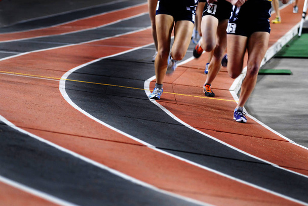 Correr una carrera en una competición deportiva de pista
 - Foto, imagen