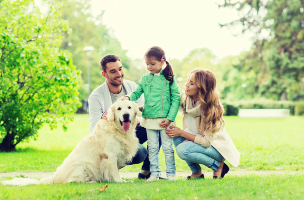 happy family with labrador retriever dog in park - Фото, зображення