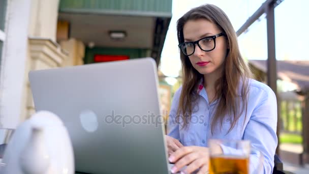Kaunis nuori nainen työskentelee kahvilassa ulkona
 - Materiaali, video