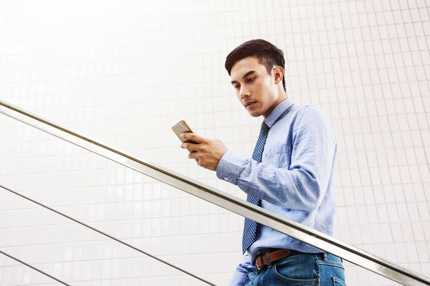 Fiatal ázsiai üzletember olvasni messge a szúró telefon-val seriousl - Fotó, kép
