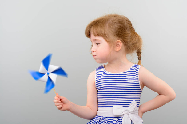niedliches Mädchen mit Windmühlenspielzeug - Foto, Bild