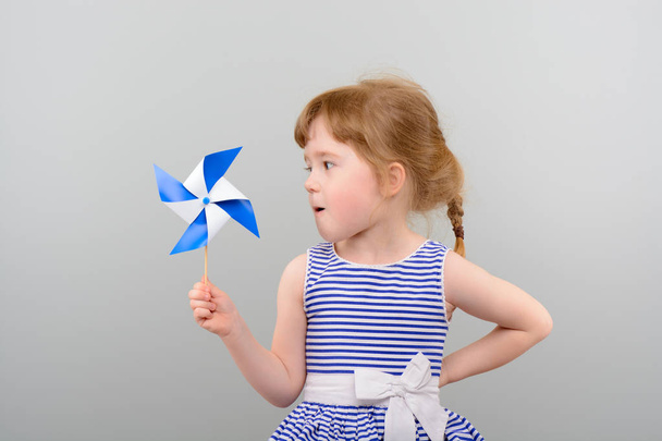Cute girl with windmill toy - Foto, Imagen