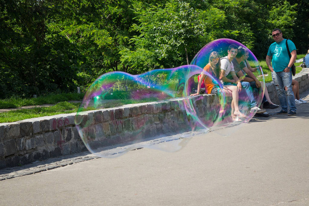 Киев, Украина - 04 июня 2016 года: Большой пузырь и отдыхающие граждане на Пейзажной аллее
 - Фото, изображение