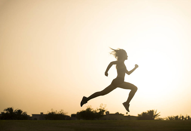 Urheilullinen nainen hyppää
  - Valokuva, kuva