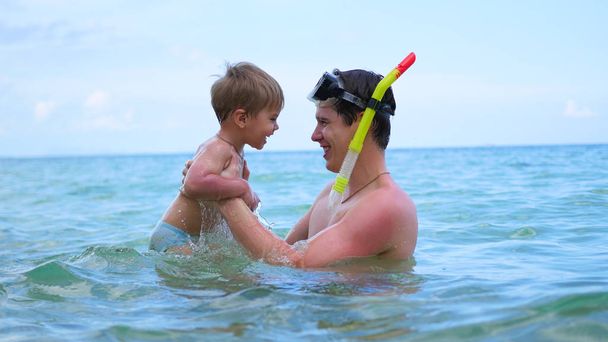 um cara com criança joga se divertindo no mar.Snorkelling
 - Foto, Imagem