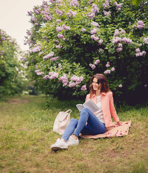Girl is reading book in park - Foto, afbeelding