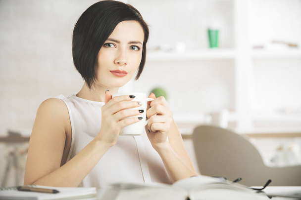 Female drinking coffee at workplace - Foto, imagen