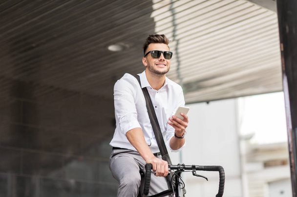 man with bicycle and smartphone on city street - Zdjęcie, obraz