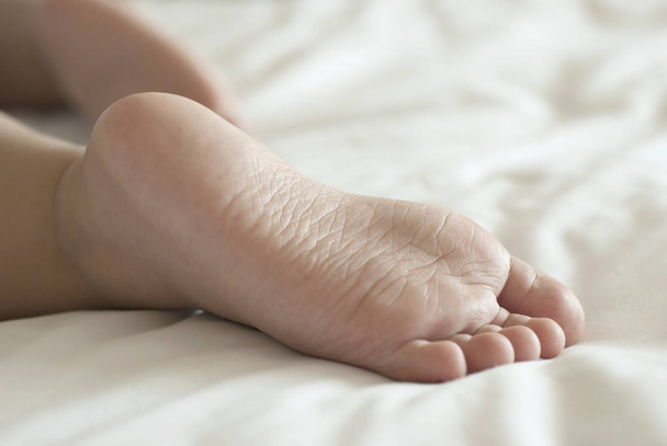 Fechar-se de pés de bebê em uma cama
 - Foto, Imagem
