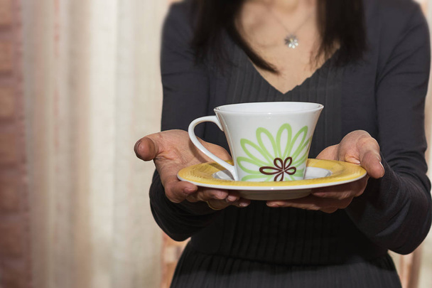 Mujer ofreciendo una taza de té (borrosa
) - Foto, Imagen