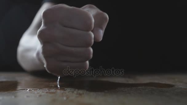 The man beats his fist on the wet table showing aggression. Concept of cruelty. - Footage, Video