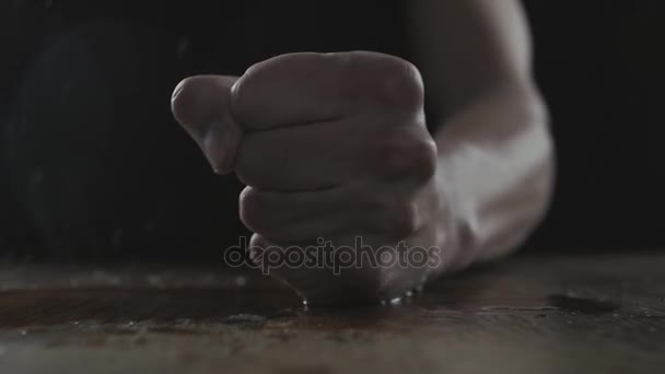 O homem bate o punho na mesa molhada mostrando agressão
 - Filmagem, Vídeo