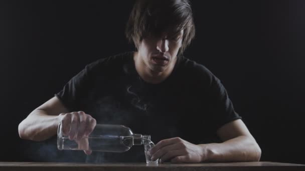 Konzept des Alkoholismus. Mann trinkt allein Wodka in einem dunklen Raum in Zeitlupe - Filmmaterial, Video