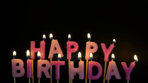 Beeldmateriaal kleurrijke brandende kaarsen ingesteld op zwarte achtergrond. Happy Birthday Kaarsen. - Video