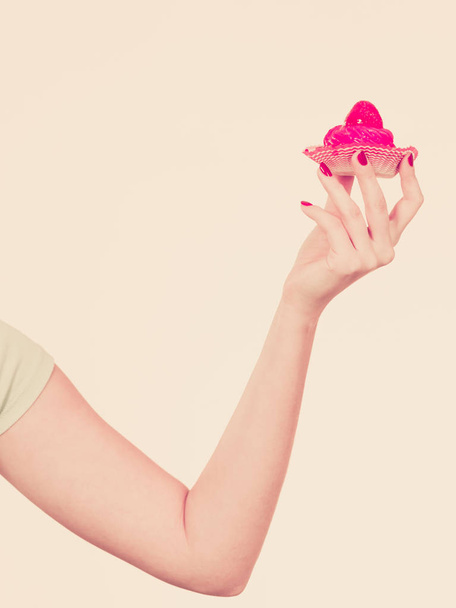 Woman hand holding sweet strawberry cupcake - Foto, imagen