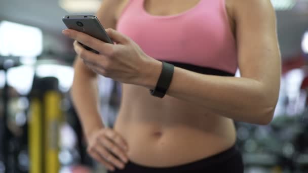 Girl tracking weight loss and muscle gain with mobile application on her phone - Video, Çekim