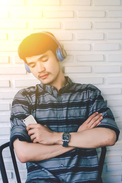 hipster młody gej słuchania muzyki słuchawki. - Zdjęcie, obraz