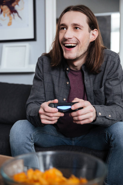 Smiling man gamer play games with joystick - Valokuva, kuva