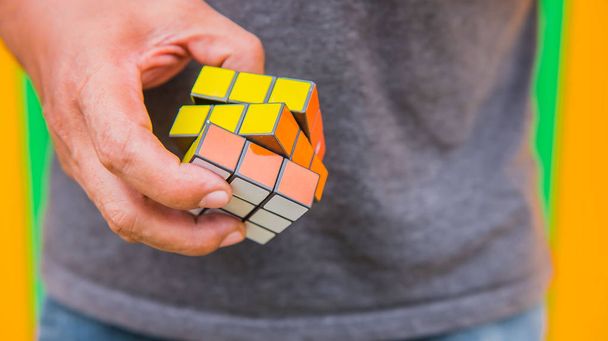  Головоломка куб Рубіка в руках людей. Куб був винайдений Угорська архітектор Ерно кубик в 1974. - Фото, зображення