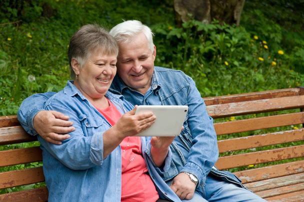 Ένα ζευγάρι από συνταξιούχους Χρησιμοποιήστε ένα δισκίο για να βρείτε πληροφορίες σχετικά με t - Φωτογραφία, εικόνα