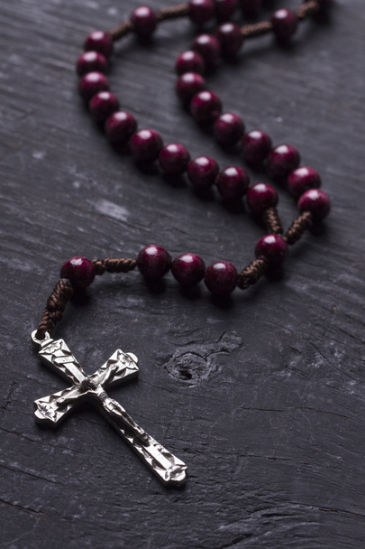 Rosary with a Christian cross on a dark wooden background. - Valokuva, kuva
