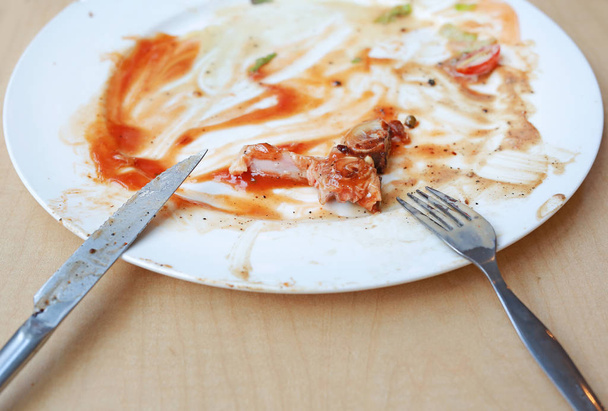 Dirty dishes of steak after eaten with knife and fork. - 写真・画像
