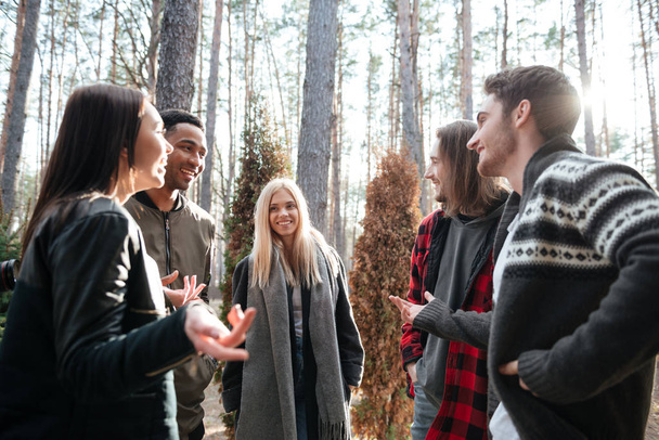 Happy group of friends standing outdoors in the forest - Photo, Image