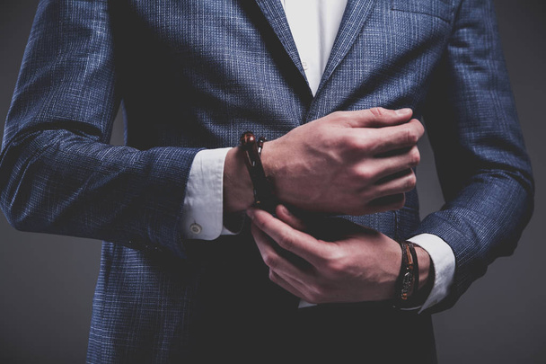 young businessman handsome model man dressed in elegant blue suit with accessories on hands  - Φωτογραφία, εικόνα