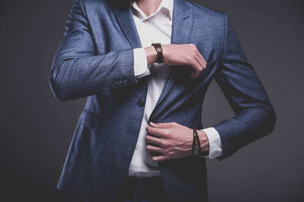 молодий бізнесмен красива модель чоловіка, одягнений в елегантний синій костюм з аксесуарами на руках
  - Фото, зображення