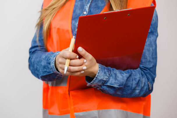 Woman engineer construction builder holds file pad. - 写真・画像