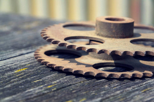 Imagen filtrada de ruedas dentadas sobre un fondo de madera colorido
 - Foto, imagen