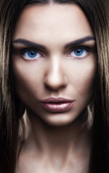 Portret van mooie vrouw met glinsterende haren in studio - Foto, afbeelding