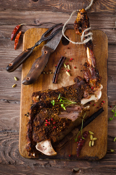 Grilled spicy lamb legs on wooden board. Ramadan food. Selective focus - Foto, Imagen