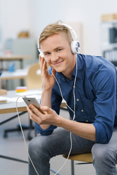 Smiling happy young businessman listening to music - Foto, afbeelding