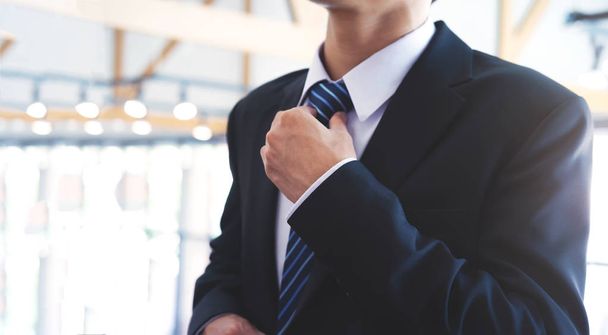 Empresário ajustando sua gravata no pescoço
. - Foto, Imagem