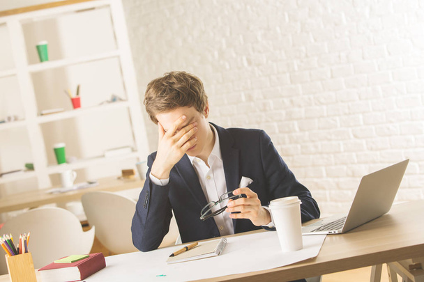 Stressed man at workplace - Фото, изображение