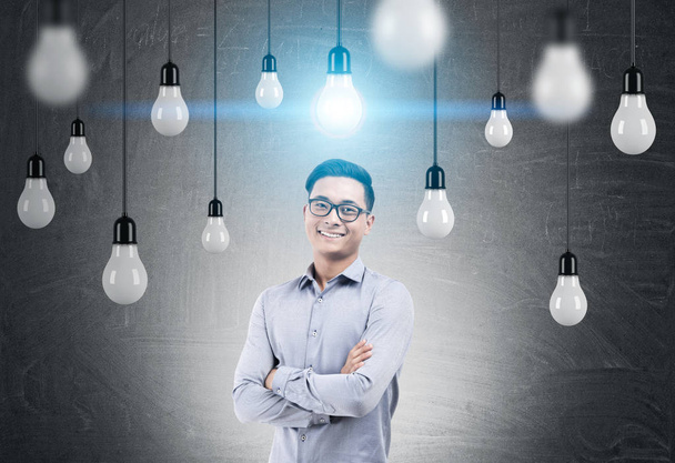 Smiling Asian man and light bulbs on wires - Valokuva, kuva