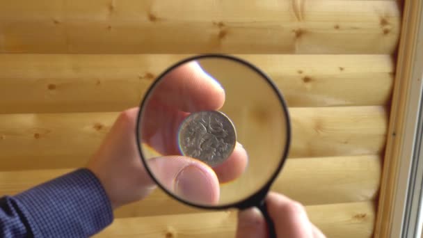 古銭学者考慮虫眼鏡を通して古い硬貨 - 映像、動画