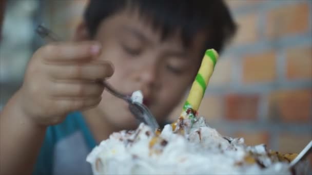 Chłopczyk jeść tort z łyżką z smaczne i bardzo szczęśliwy, - Materiał filmowy, wideo