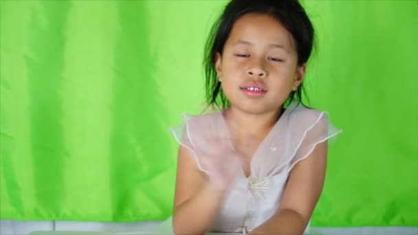 Petite fille asiatique agitant sa main en disant au revoir sur fond vert
, - Séquence, vidéo