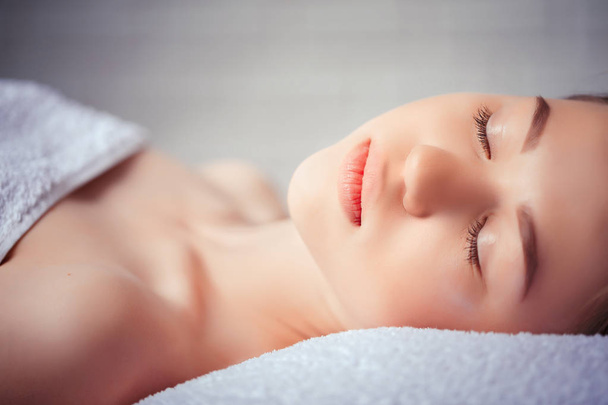 health, beauty, resort and relaxation concept - beautiful woman in spa salon lying on the massage desk - Φωτογραφία, εικόνα