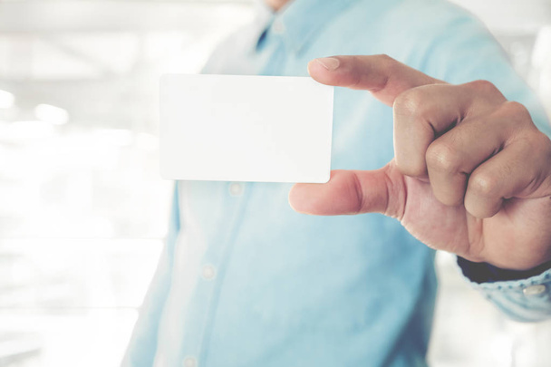 Young business man holding white business card - 写真・画像