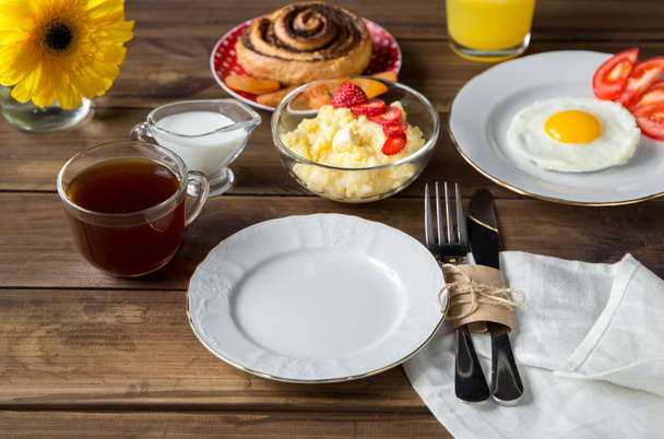 Mesa de desayuno servida con gachas de maíz, huevo frito y jugo
 - Foto, Imagen